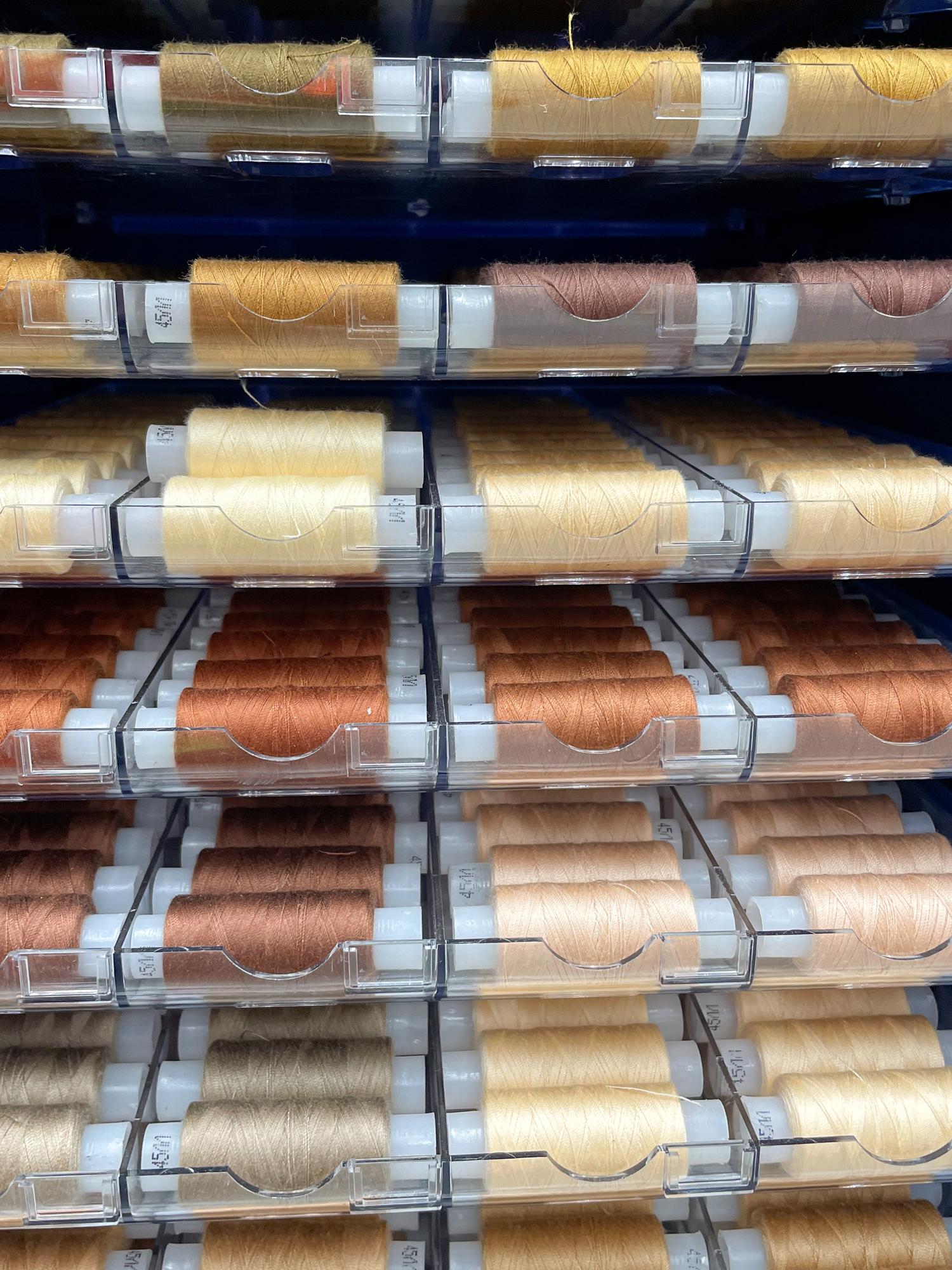 Sample swatches and thread spools arranged for pricing